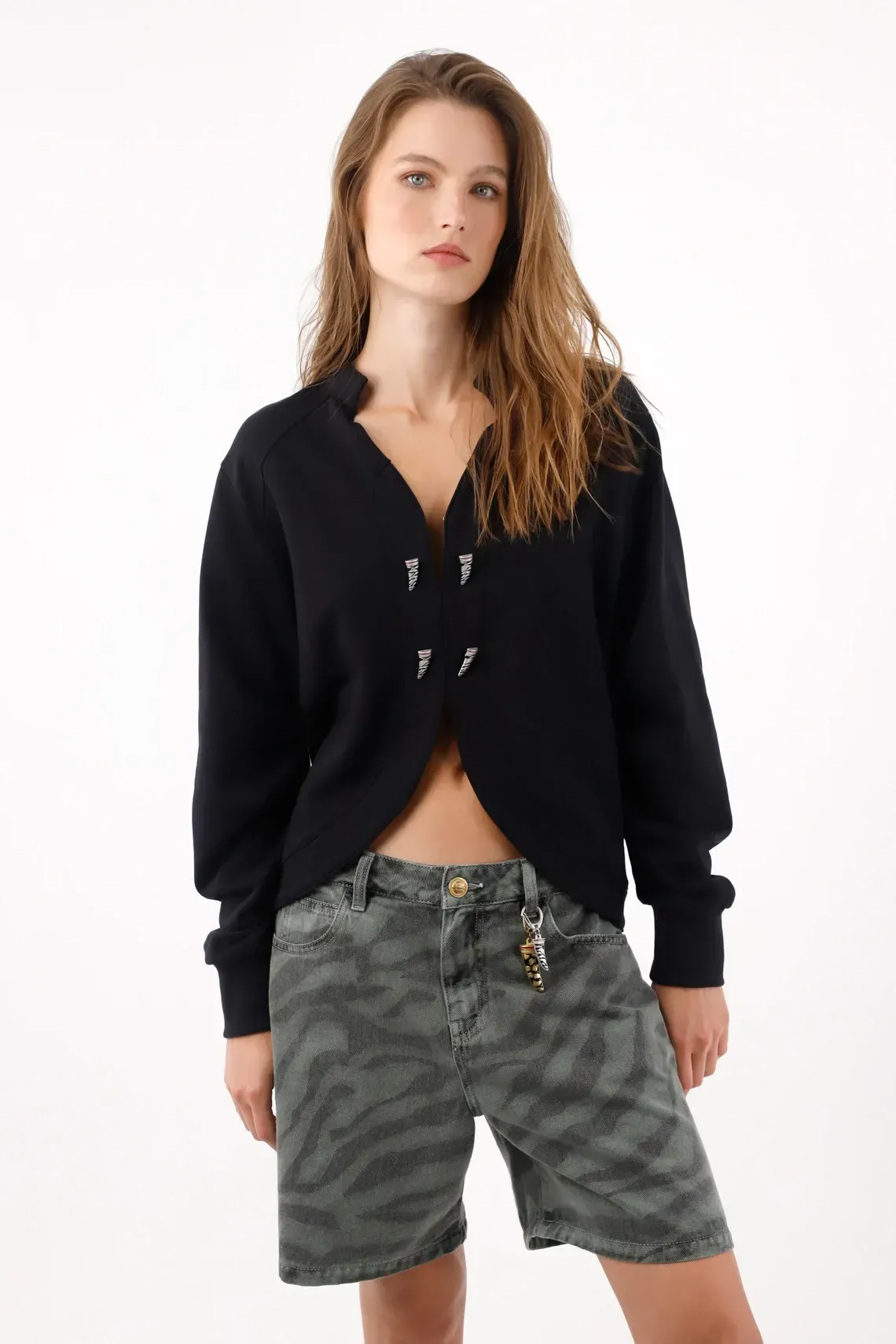 Buzo de corte corto con frente curvo abierto y apliques en algodón negro para mujer